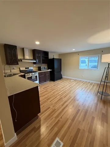 a kitchen with stainless steel appliances a stove top oven a sink and a microwave