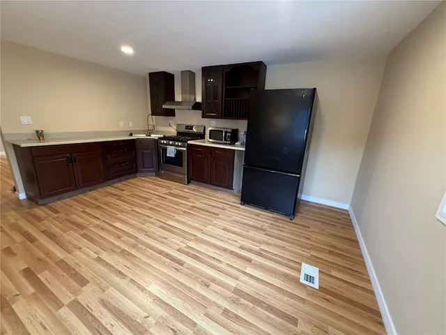 a kitchen with stainless steel appliances granite countertop a refrigerator and a sink