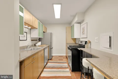 a kitchen with stainless steel appliances granite countertop a sink stove and refrigerator