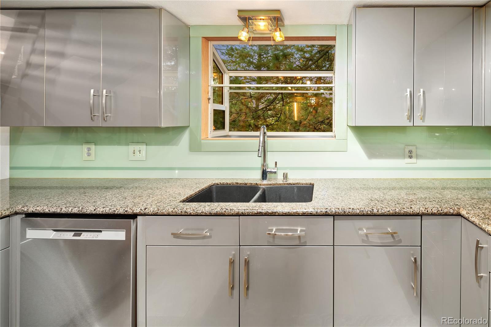 28696 Little Big Horn Drive Evergreen, CO 80439 - Photo 19 of 47 a kitchen with granite countertop a sink and a white wooden cabinets
