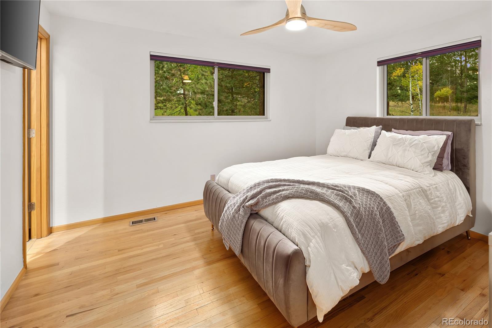28696 Little Big Horn Drive Evergreen, CO 80439 - Photo 22 of 47 a bed sitting in a bedroom next to a window