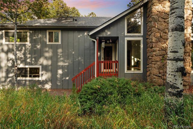 a yellow house with wooden fence and porch