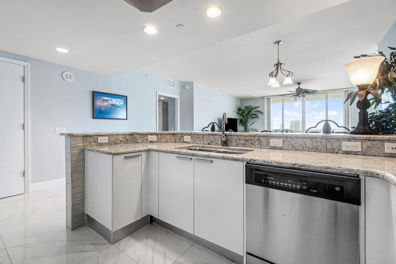2640 Lake Shore Drive, Unit 1216 Riviera Beach, FL 33404 - Photo 14 of 60 a kitchen with granite countertop a sink and a stove