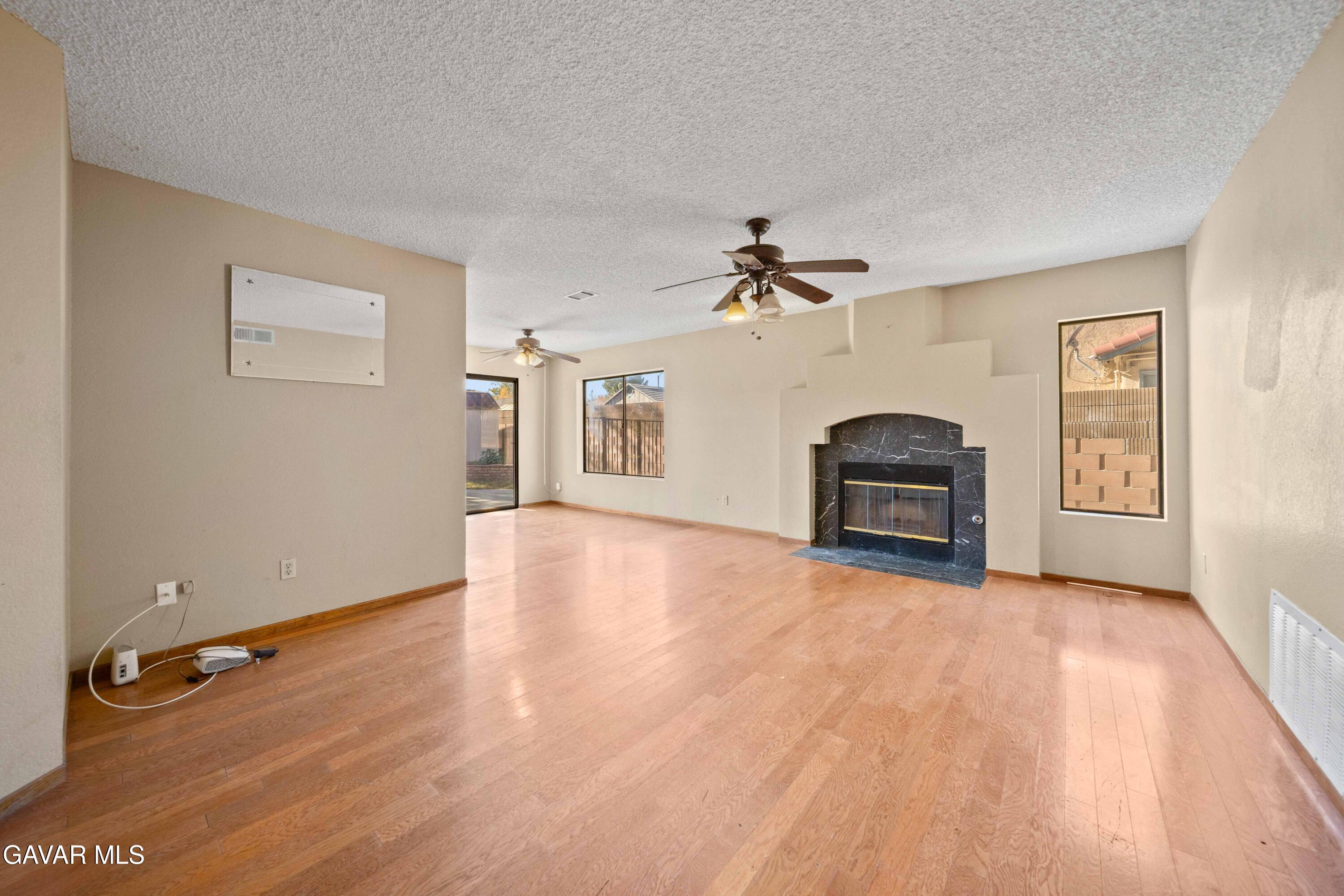 44200 Galion Avenue Lancaster, CA 93536 - Photo 11 of 42 a view of an empty room with a window and wooden floor