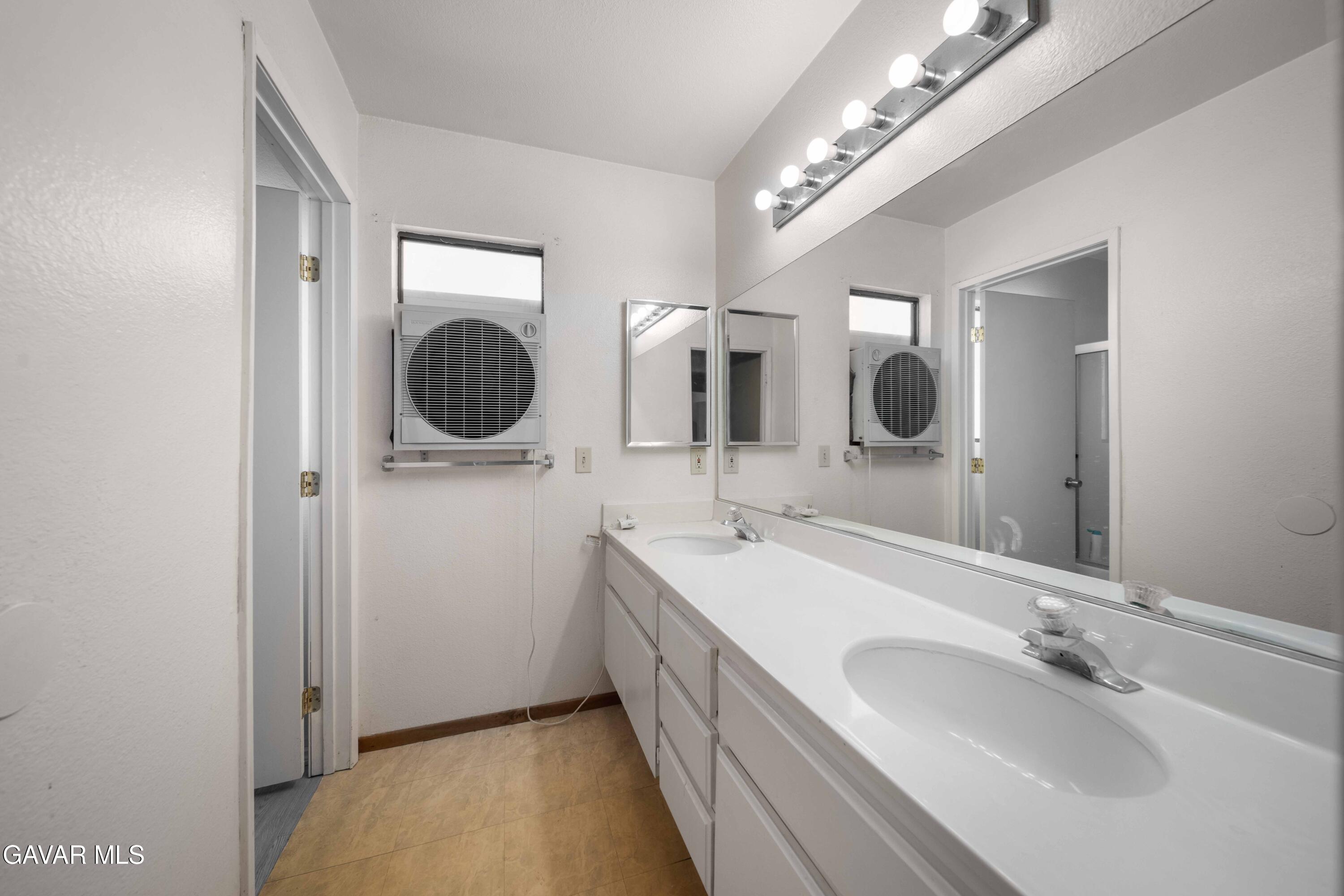 44200 Galion Avenue Lancaster, CA 93536 - Photo 17 of 42 a bathroom with a double vanity sink and a mirror