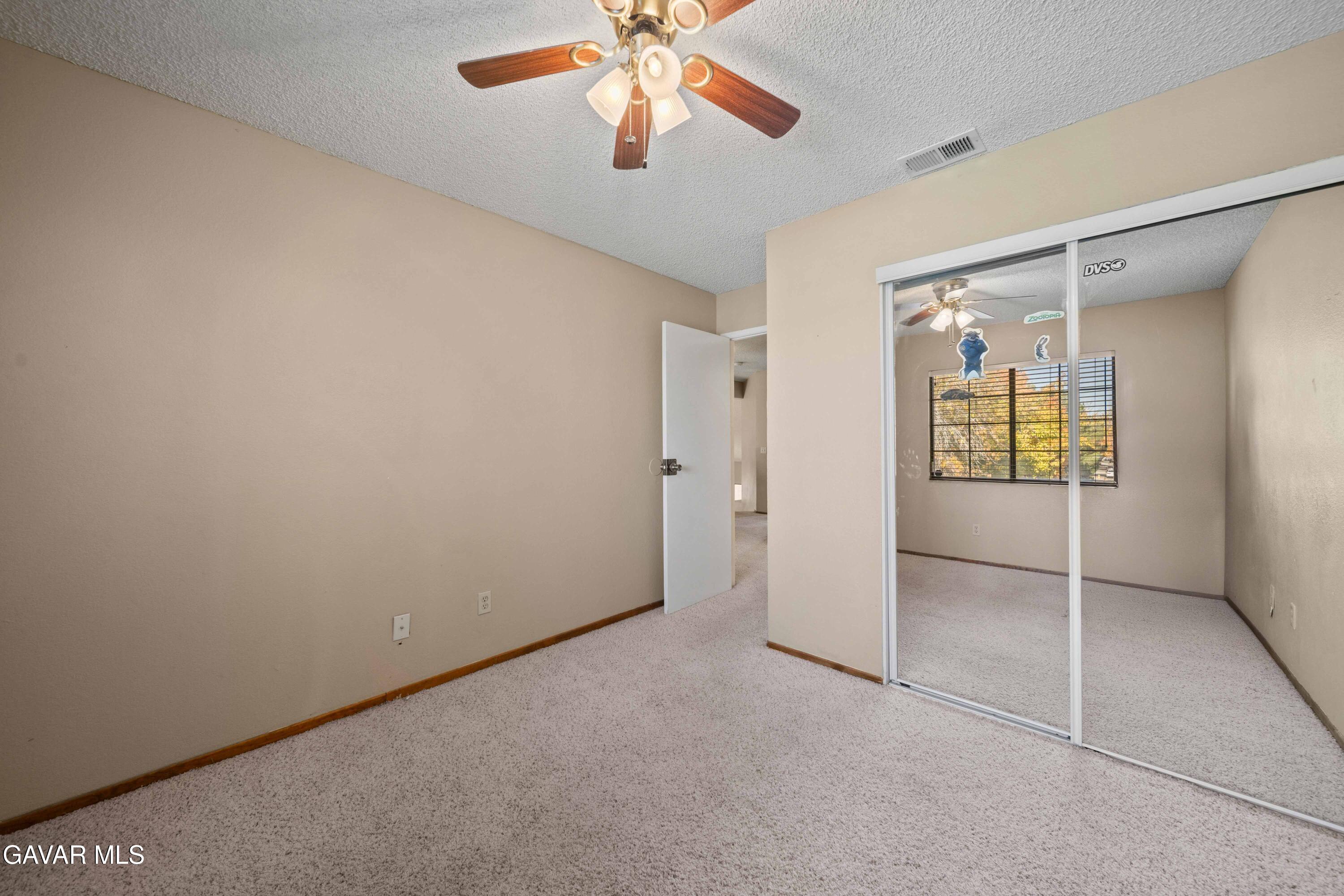 44200 Galion Avenue Lancaster, CA 93536 - Photo 26 of 42 an empty room with chandelier fan and windows