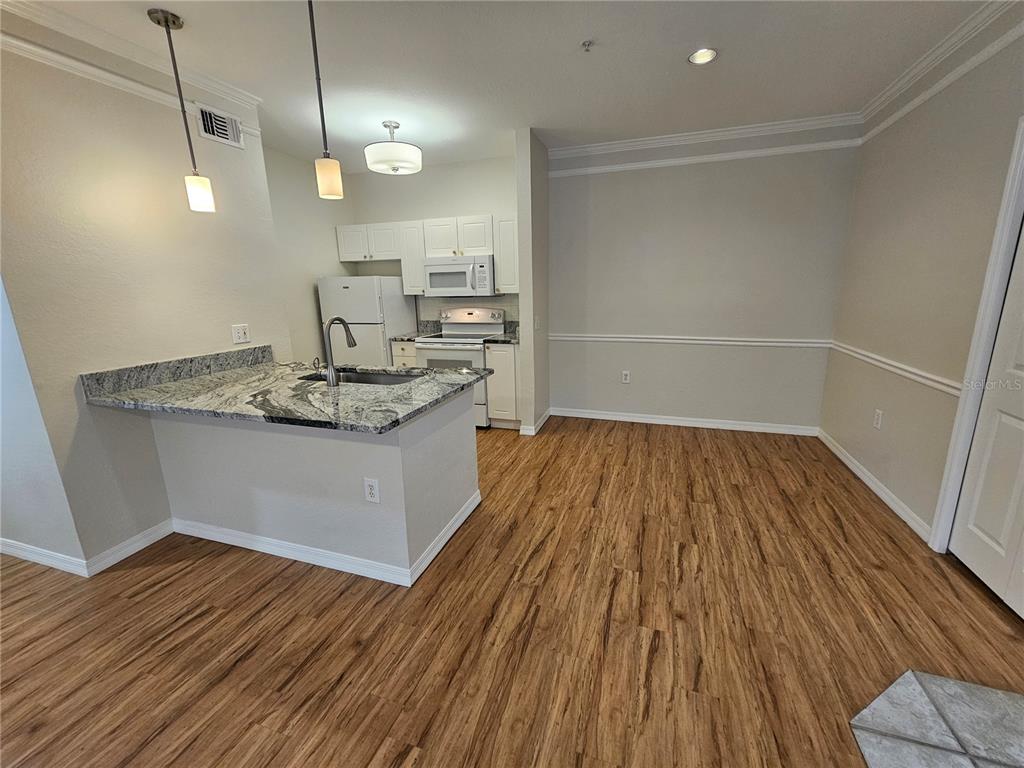 5174 Northridge Road, Unit 209 Sarasota, FL 34238 - Photo 8 of 25 a hallway view with wooden floor and large windows