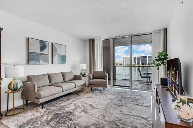 a living room with furniture a flat screen tv and a large window