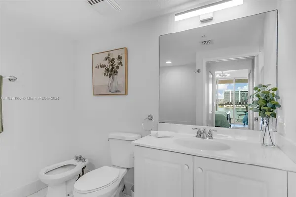a bathroom with a granite countertop toilet sink and mirror