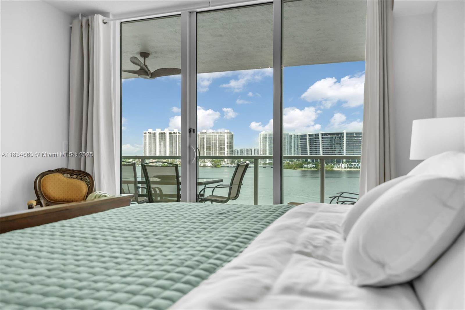 18100 North Bay Road, Unit 709 Sunny Isles Beach, FL 33160 - Photo 14 of 33 a bedroom with a bed and glass windows