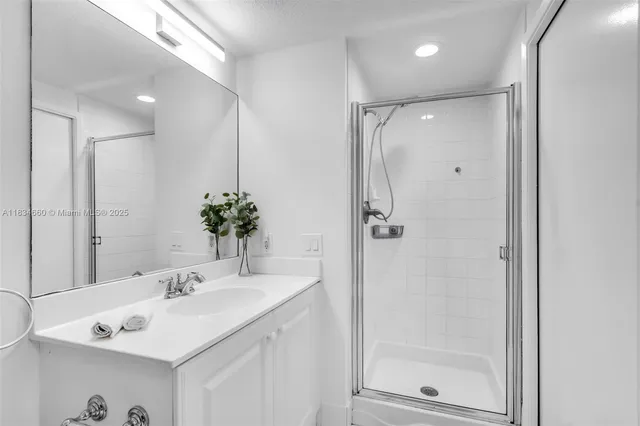 a bathroom with a shower sink vanity and mirror