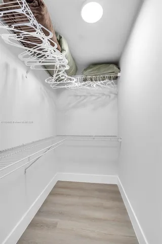 a view of a room with water heater and racks on the wall