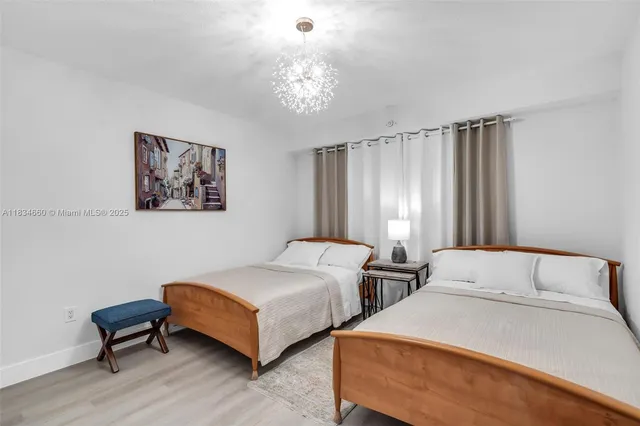 a bedroom with two beds and a chandelier