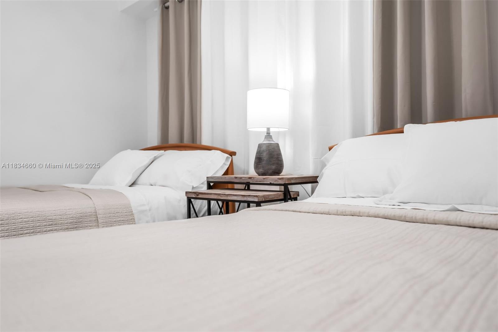 18100 North Bay Road, Unit 709 Sunny Isles Beach, FL 33160 - Photo 22 of 33 a bedroom with a bed and a window