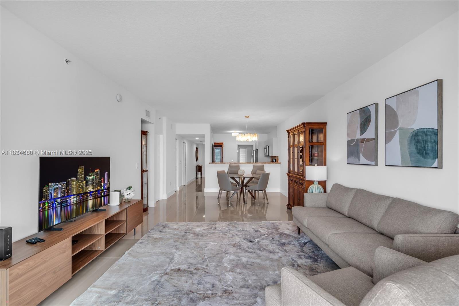 18100 North Bay Road, Unit 709 Sunny Isles Beach, FL 33160 - Photo 5 of 33 a living room with furniture and a flat screen tv
