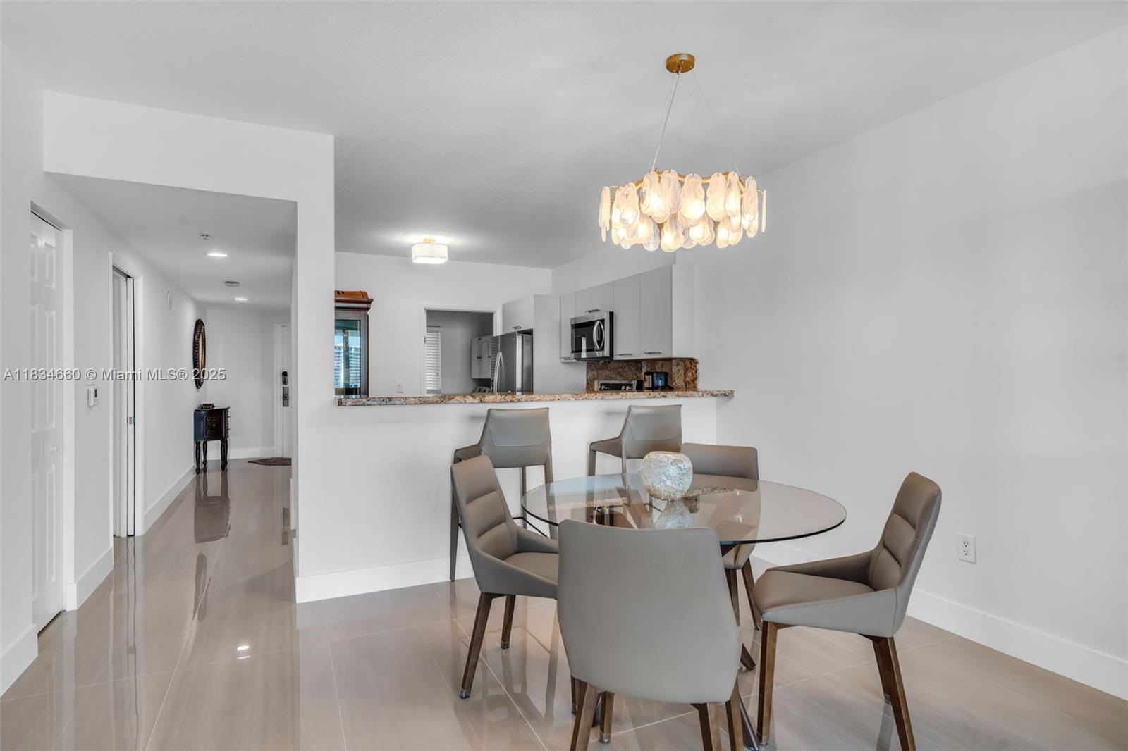18100 North Bay Road, Unit 709 Sunny Isles Beach, FL 33160 - Photo 6 of 33 a view of a dining room with furniture and chandelier