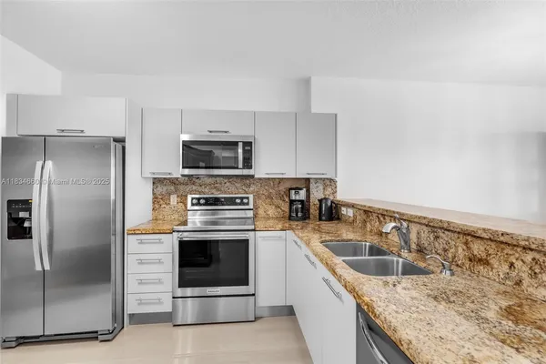 a kitchen with granite countertop a sink stove and refrigerator