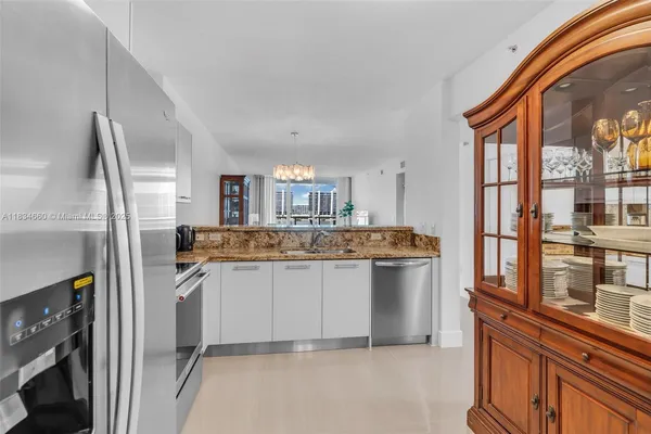 a kitchen with stainless steel appliances granite countertop a sink and a refrigerator