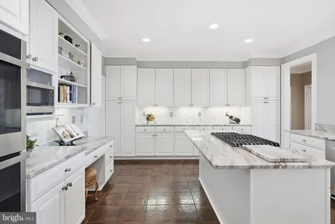 a kitchen with granite countertop white cabinets and stainless steel appliances
