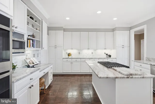 a kitchen with granite countertop white cabinets and stainless steel appliances