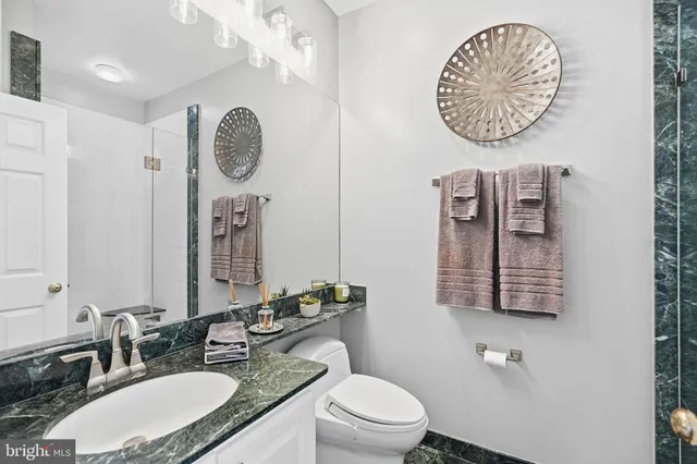 a bathroom with a toilet a sink and mirror