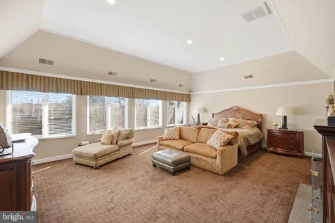 a spacious bedroom with a bed couch and a large window