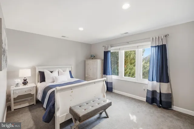 a spacious bedroom with a bed and a window