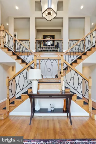 a view of staircase with a dining table a mirror and a chandelier