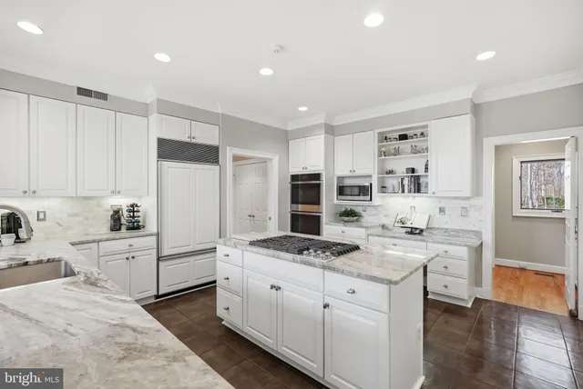 a kitchen with white cabinets and appliances
