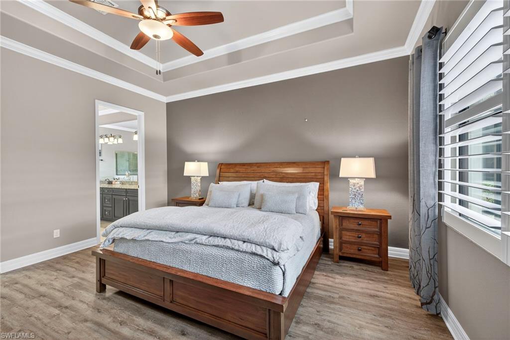 9352 Vercelli Court Naples, FL 34113 - Photo 20 of 49 a bedroom with a bed and a chandelier