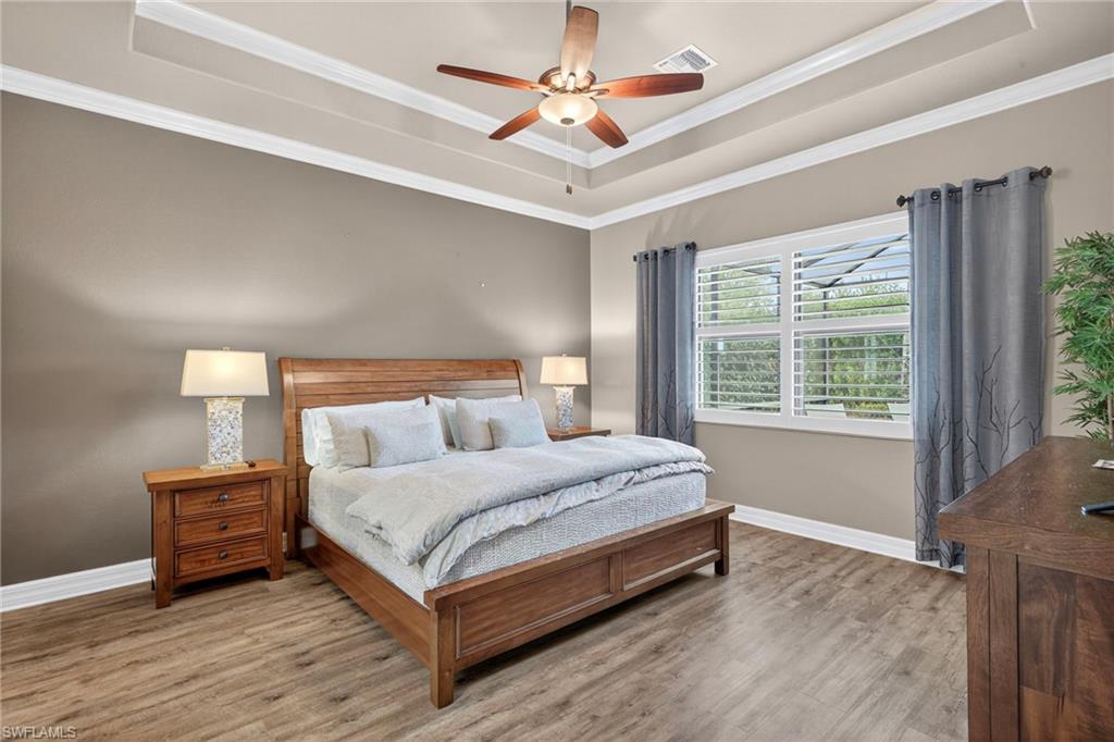 9352 Vercelli Court Naples, FL 34113 - Photo 22 of 49 a bedroom with a bed chandelier and a large window