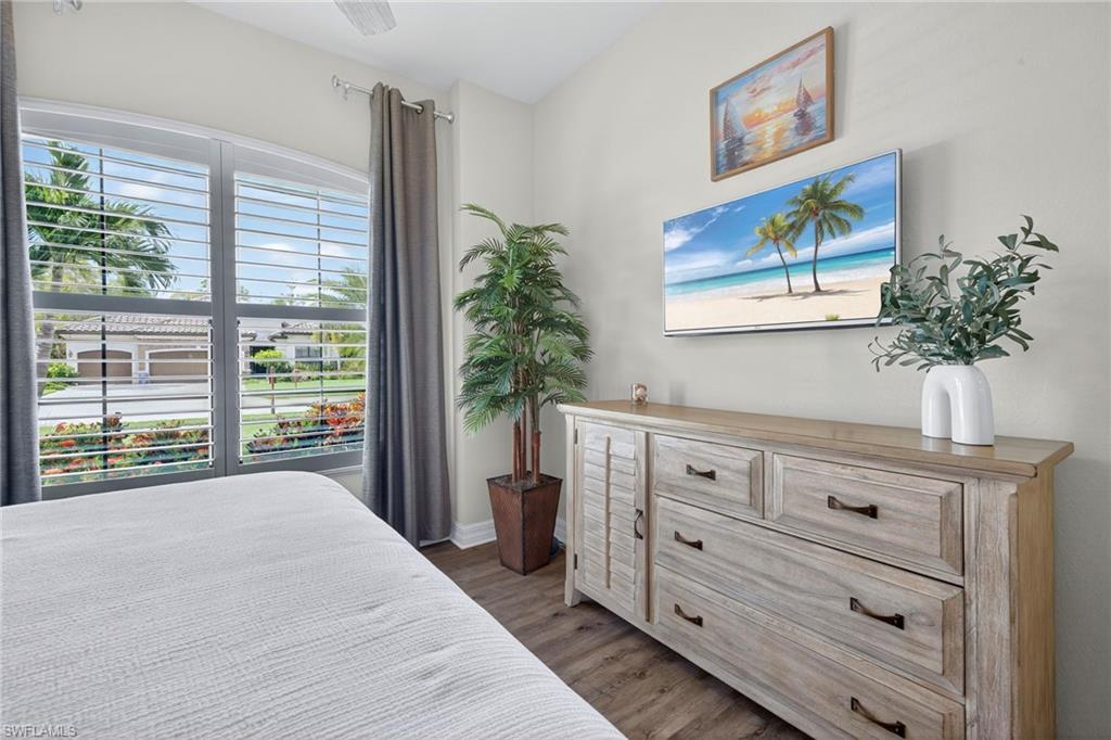9352 Vercelli Court Naples, FL 34113 - Photo 27 of 49 a bedroom with a bed and a potted plant on the dresser