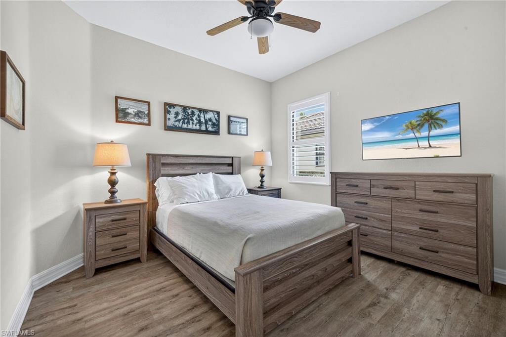 9352 Vercelli Court Naples, FL 34113 - Photo 29 of 49 a bedroom with a bed and a chandelier