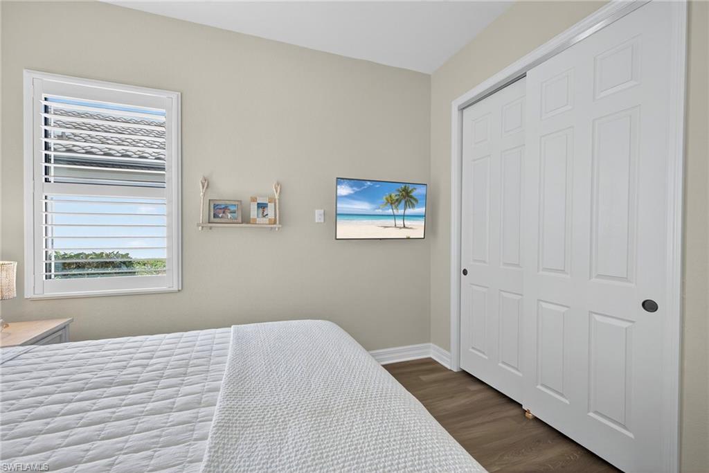 9352 Vercelli Court Naples, FL 34113 - Photo 31 of 49 a view of a bedroom with wooden floor and a window