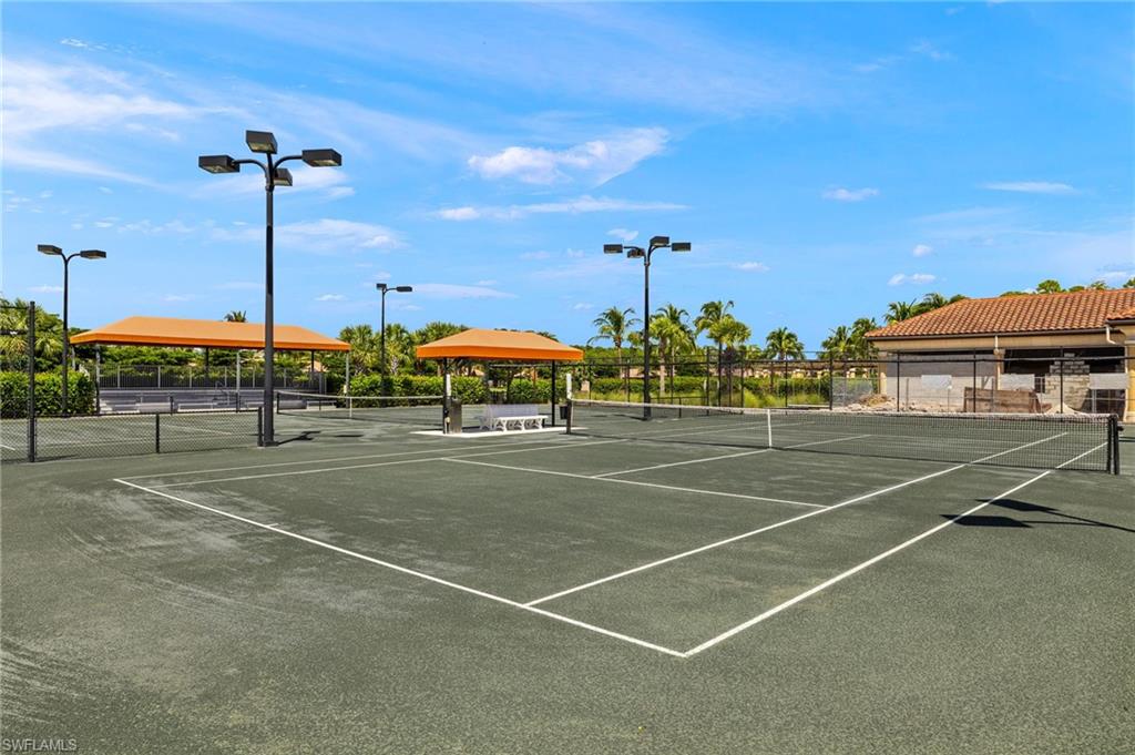 9352 Vercelli Court Naples, FL 34113 - Photo 48 of 49 a view of a tennis ground with a table and chairs