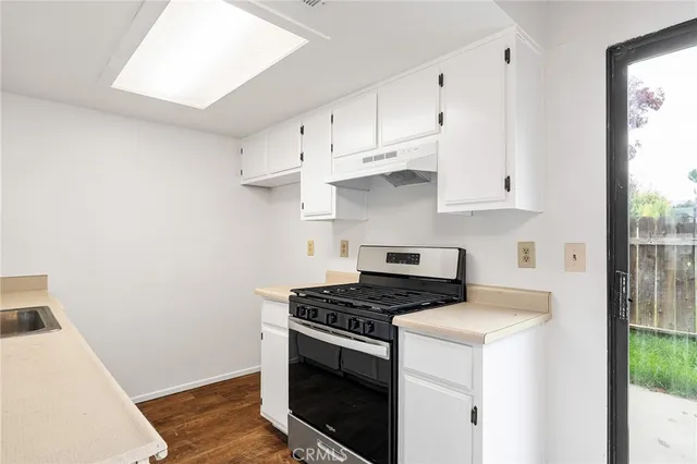 a kitchen with granite countertop white cabinets and white appliances