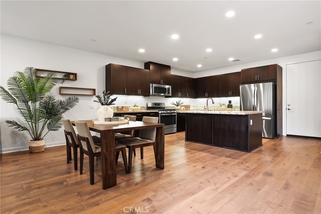 53 Savannah Lake Forest, CA 92630 - Photo 1 of 1 a kitchen with stainless steel appliances kitchen island granite countertop a table and chairs in it