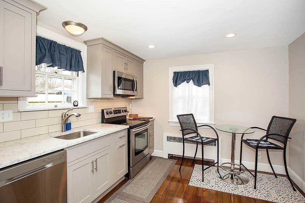 10 Standish Road Milton, MA 02186 - Photo 12 of 27 a kitchen with stainless steel appliances granite countertop a stove a sink dishwasher and a microwave oven with white cabinets