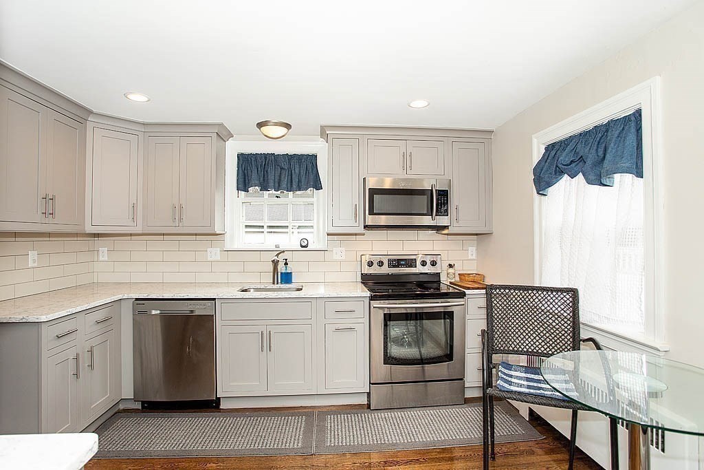 10 Standish Road Milton, MA 02186 - Photo 13 of 27 a kitchen with cabinets stainless steel appliances and wooden floor