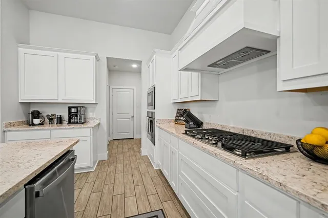 a kitchen with stainless steel appliances granite countertop a stove a sink and a refrigerator