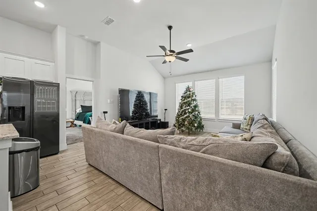 a living room with furniture and a wooden floor