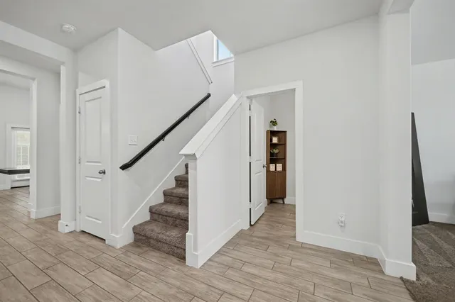 a view of hallway with stairs and wooden floor