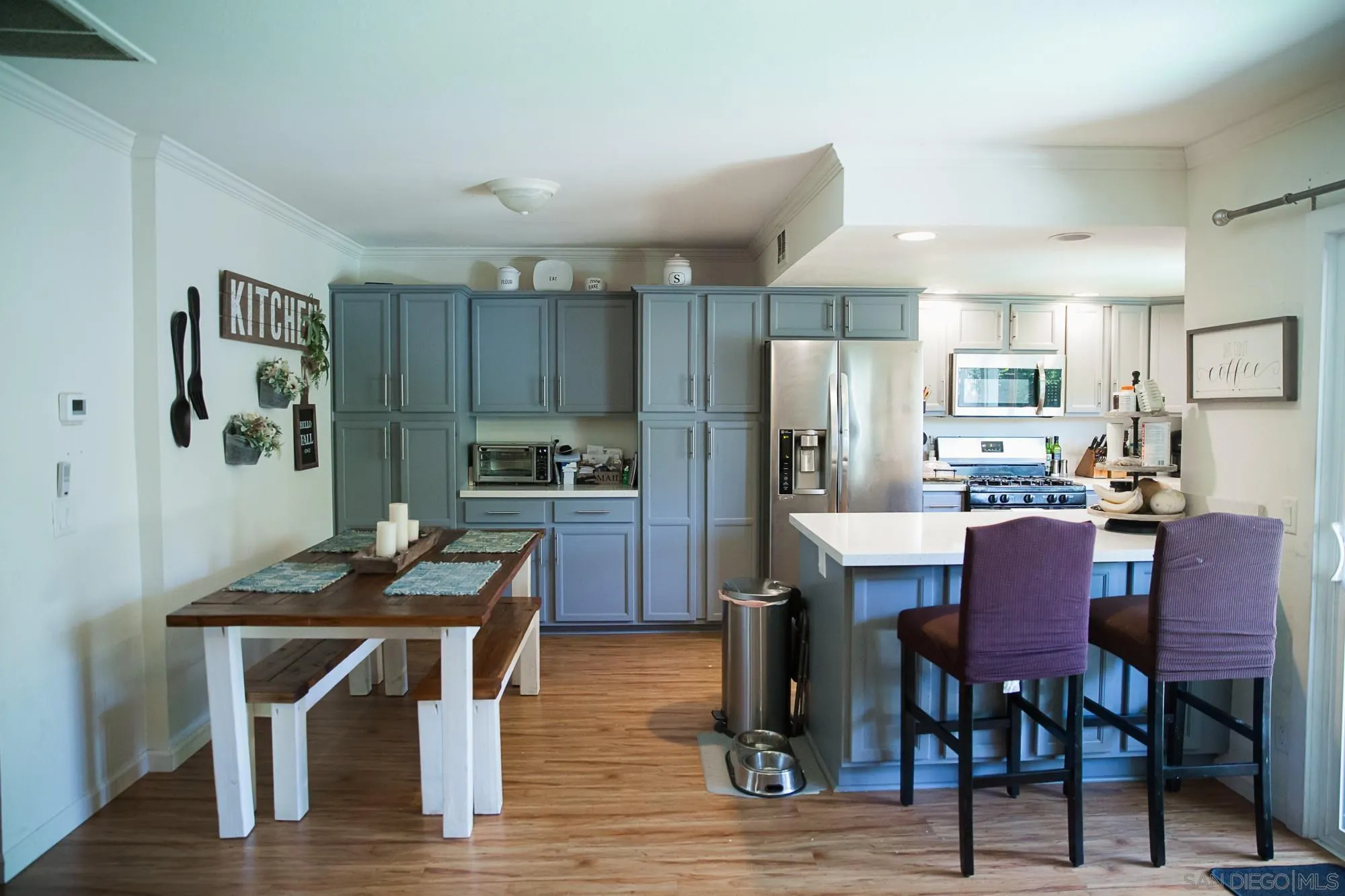 44547 La Paz Road Temecula, CA 92592 - Photo 3 of 30 a kitchen with a dining table chairs refrigerator and cabinets