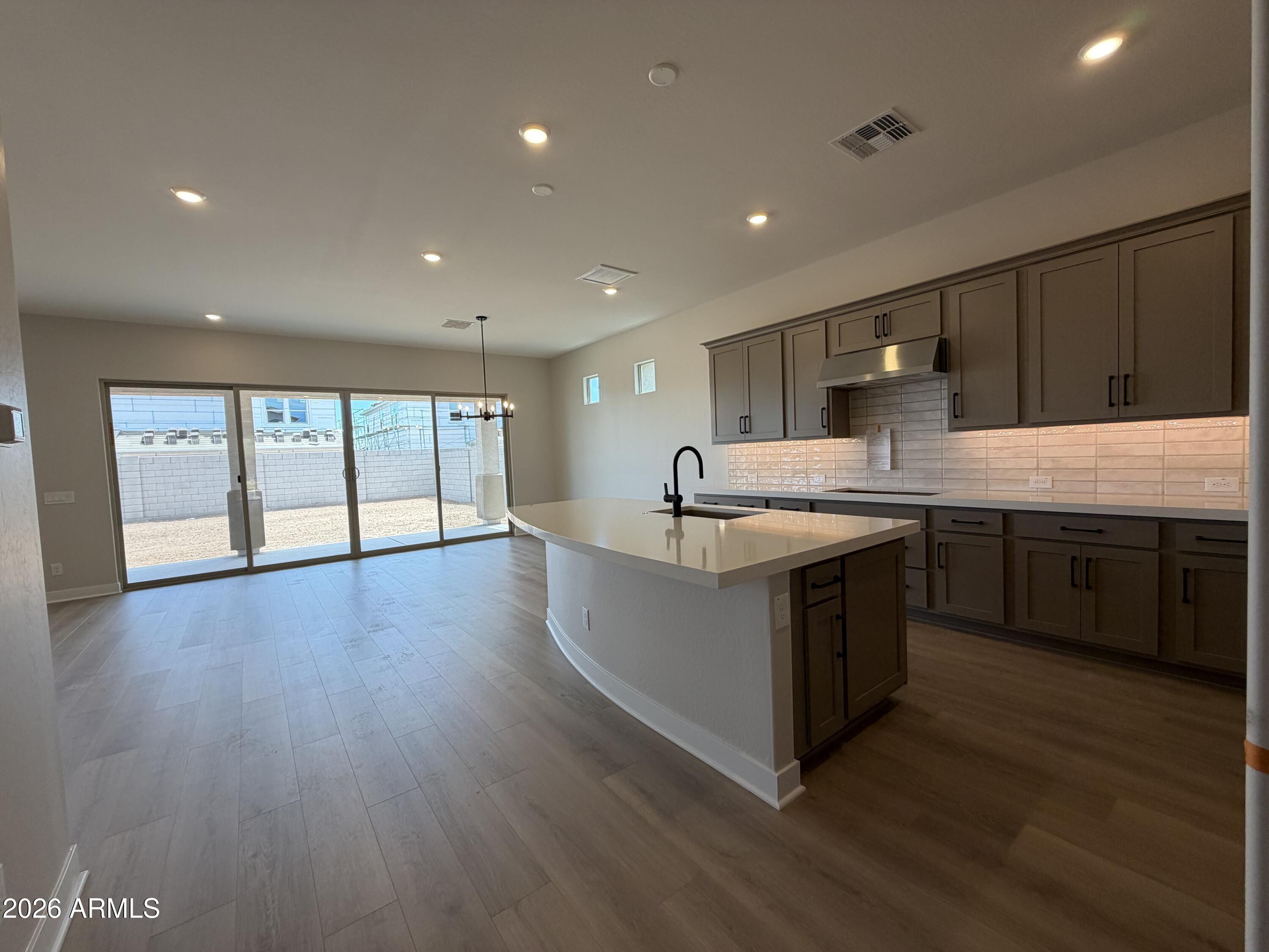 15767 West Sand Hills Road Surprise, AZ 85387 - Photo 4 of 60 a large kitchen with stainless steel appliances granite countertop a large counter top a stove and a wooden floors