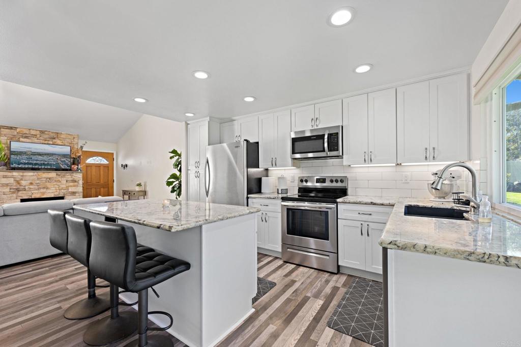3681 Harvard Drive Oceanside, CA 92056 - Photo 10 of 30 a kitchen with granite countertop a sink stove and refrigerator