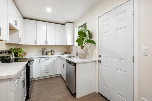a kitchen with granite countertop white cabinets and white appliances