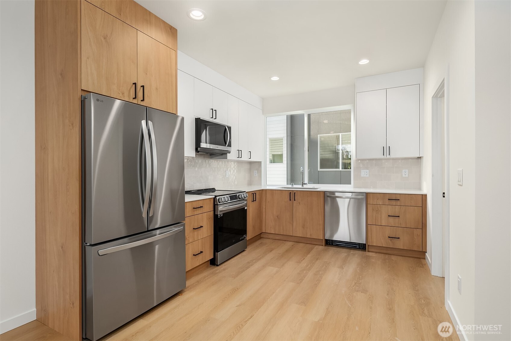 18017 2nd Avenue Northeast, Unit B Seattle, WA 98155 - Photo 2 of 19 a kitchen with white cabinets and stainless steel appliances