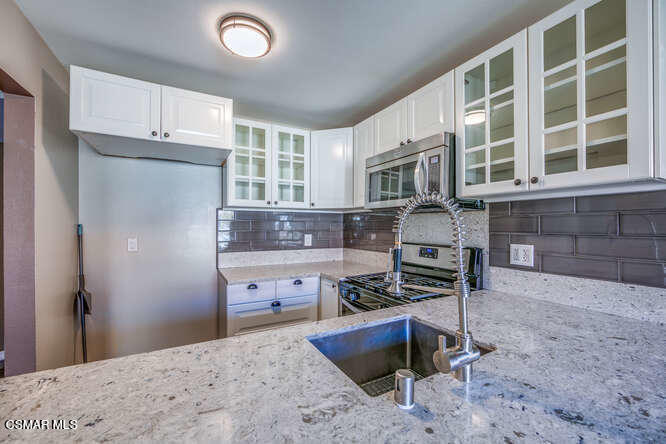 1766 Sinaloa Road, Unit 279 Simi Valley, CA 93065 - Photo 12 of 23 a kitchen with granite countertop a stove refrigerator and cabinets