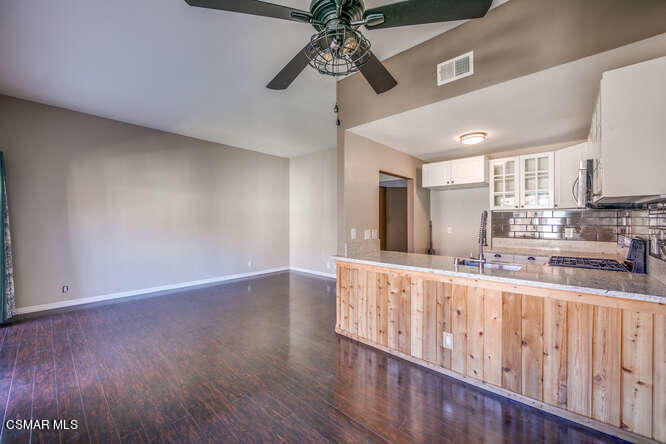 1766 Sinaloa Road, Unit 279 Simi Valley, CA 93065 - Photo 13 of 23 a large kitchen with stainless steel appliances a large window a oven and a sink with wooden floor