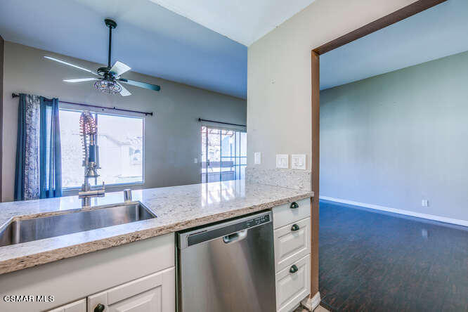 1766 Sinaloa Road, Unit 279 Simi Valley, CA 93065 - Photo 10 of 23 a kitchen with granite countertop a sink and dishwasher with wooden floor